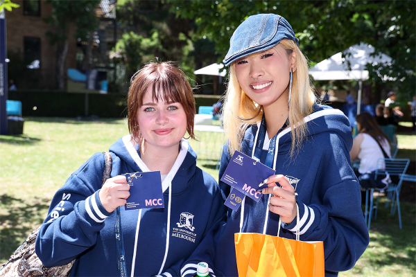 Two students holding Melbourne Commencement Ceremony lanyards