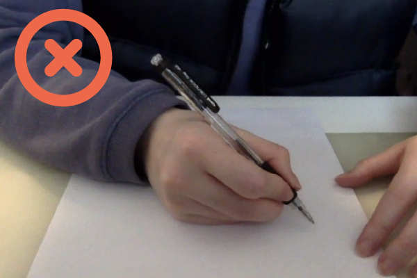 Student sitting exam. Unacceptable - objects within reach are not visible, the student can't be identified and your working out shouldn't be readable.