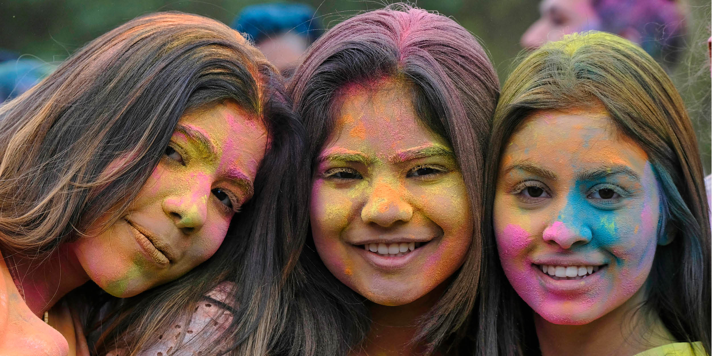 Three students celebrating Holi
