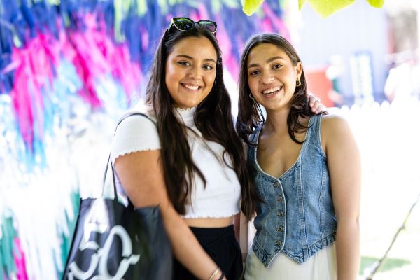 Two students in front of blue and pink backdrop