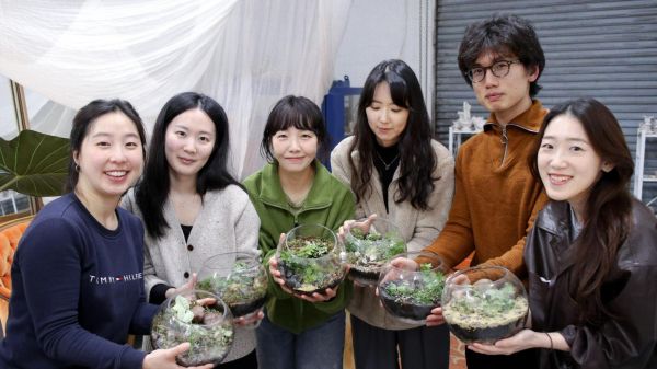 4 people holding terrariums 