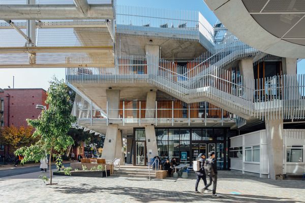 Students walking across the sunny student pavilion