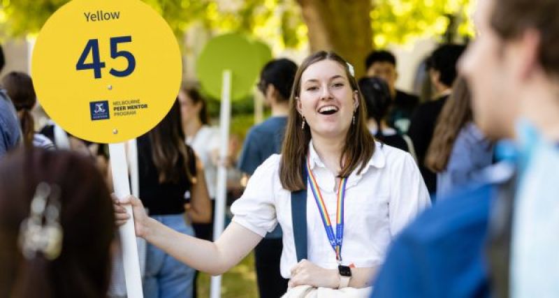 A Peer Mentor holding a sign 