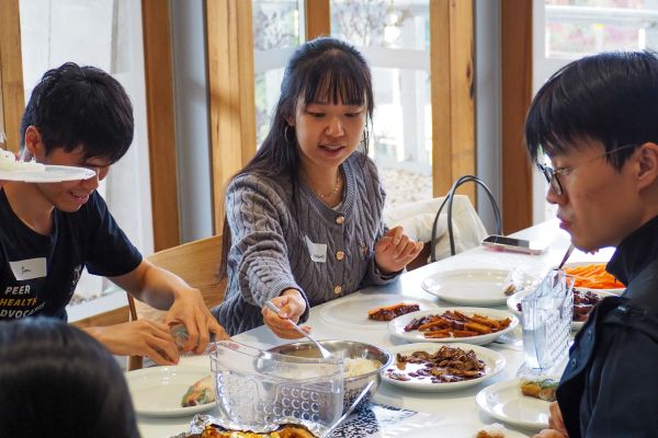 Three people enjoying a meal together at a Cooking Workshop