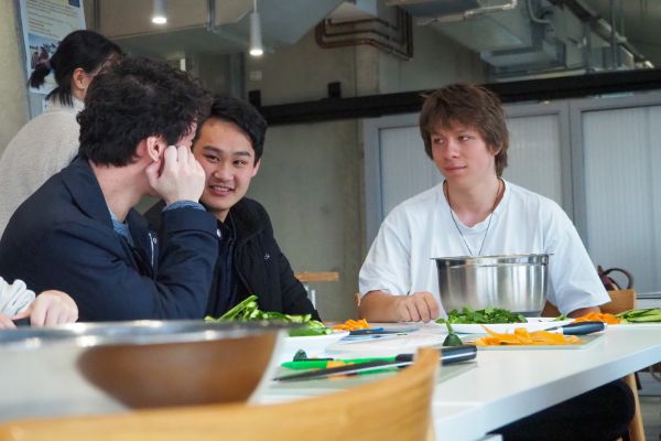 Three students chatting at a table during a Cooking Workshop