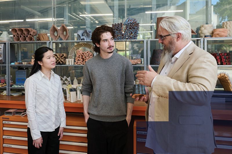 Two students talking with an academic