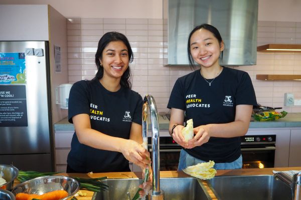 Two students washing produce at a Cooking Workshop