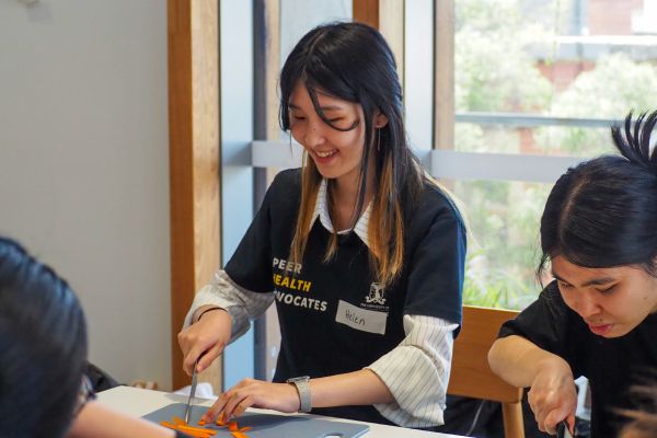Two Cooking Workshop students chopping produce and smiling