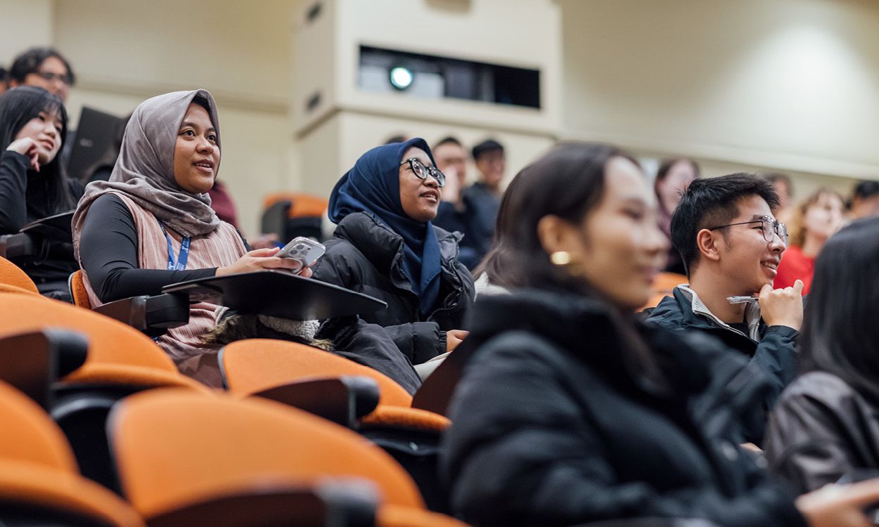 Students attend a lecture in a University lecture theatre.