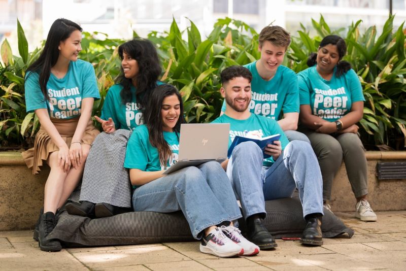 Five students wearing teal 