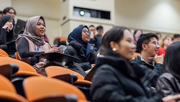 Students attend a lecture in a University lecture theatre.