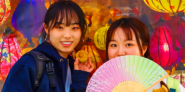 Two students with colourful lanterns and a fan