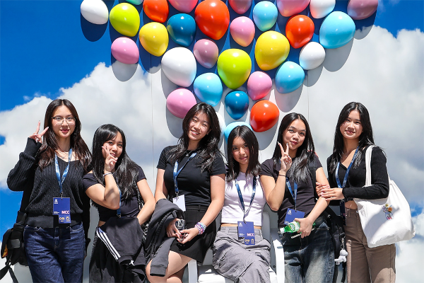 Six students with balloon and cloud photo backdrop