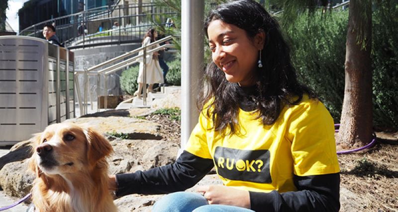 A smiling woman in a yellow 