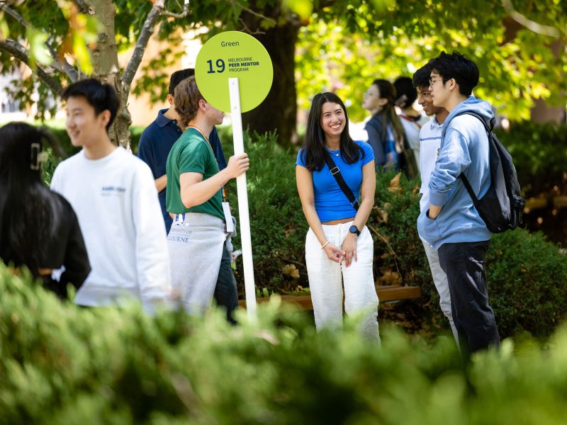 Students gathered outdoors, with a green MPMP sign