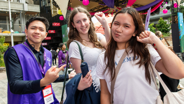 Three students posing in front of UMSU stage